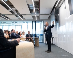 A man presenting to a group of people in a modern conference room.