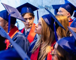 A group of graduates wearing caps and gowns during a ceremony.