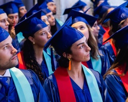 A group of graduates wearing caps and gowns during a ceremony.