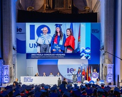 A graduation ceremony showcasing graduates receiving their diplomas on stage.