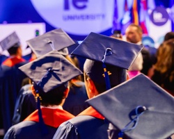 A group of graduates wearing caps and gowns at a university ceremony.