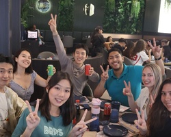 A group of friends smiling and posing with drinks in a restaurant.