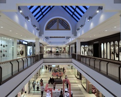 A spacious indoor shopping mall with multiple levels and various stores.