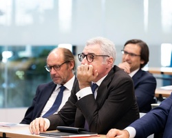 A group of businessmen attentively participating in a meeting.