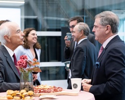 Group of professionals interacting at a networking event in a modern office space.