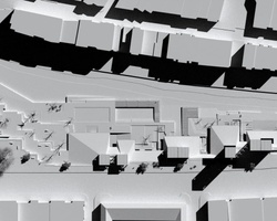 Aerial grayscale image of an urban layout showing buildings and streets.