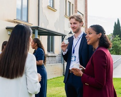 A group of professionals engaged in conversation outdoors.