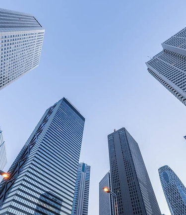 A view looking up at tall skyscrapers against a clear sky.