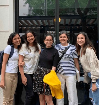 Five women smiling for a photo in front of a restaurant