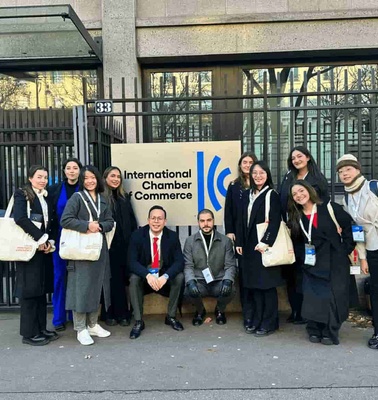 A group of people posing in front of the International Chamber of Commerce building.