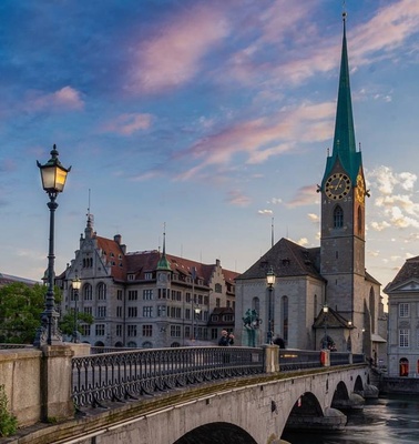A picturesque view of Zurich's historic buildings and a tower at sunset.