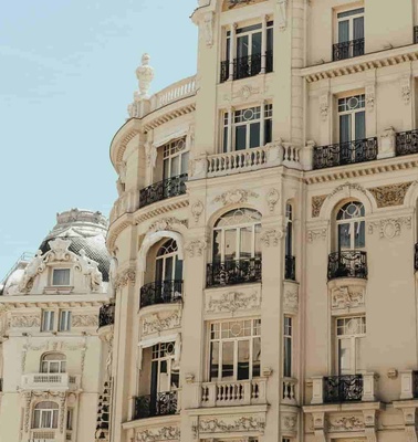 A detailed view of an ornate, classical European building with elaborate balconies and a clear blue sky.