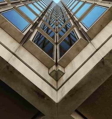 A view looking up at a tall building with triangular and geometric architectural features.
