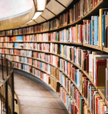 A curved library shelf filled with colorful books.