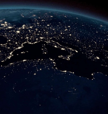 A nighttime view of Earth from space showing city lights and the curved horizon.