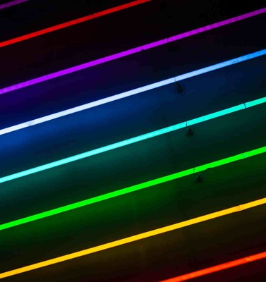 Colorful neon lights arranged in parallel lines against a dark background.