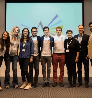 A group of ten people posing for a photo at a conference room with a European Union flag and a graphical backdrop.