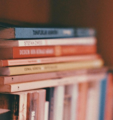 A close-up view of a stack of books arranged on a shelf.