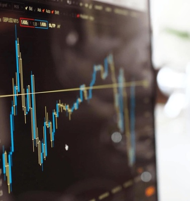 A close-up view of a computer screen displaying financial trading charts with candlestick graphs.