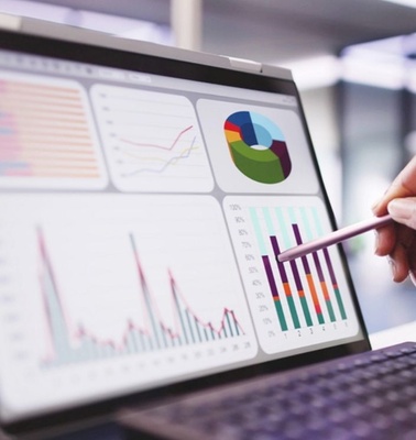 A person analyzing data on a laptop screen with various graphs and charts.