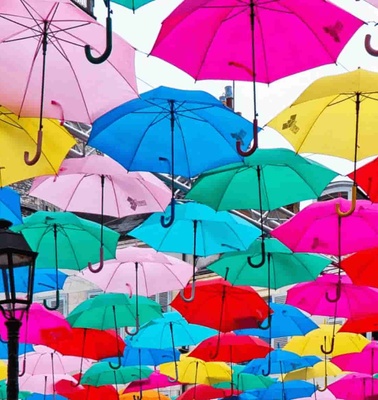 Colorful umbrellas suspended in the air above a street.