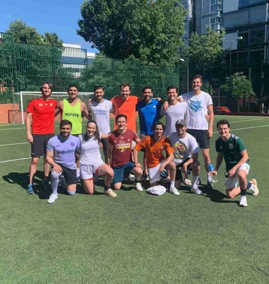 A group of people posing together on a soccer field.