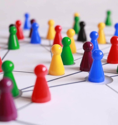 Colorful game pieces on a white board connected by lines, resembling a network or strategic game.