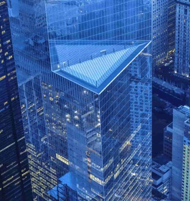 Aerial view of modern skyscrapers in a city at dusk, showcasing reflective glass facades.