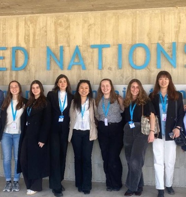 A group of people posing in front of the United Nations building.