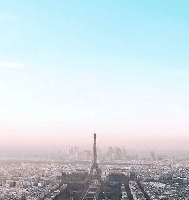 A panoramic view of Paris with the Eiffel Tower in the center during daylight.