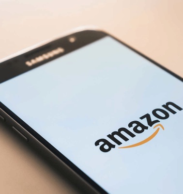 A smartphone displaying the Amazon logo on its screen.