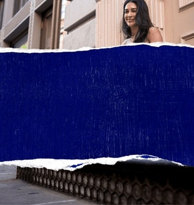 A woman standing outside a building with a stylish torn blue overlay.