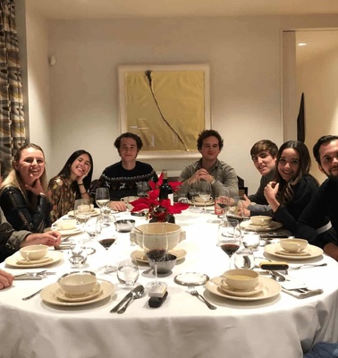 A group of people seated around a dining table in a well-lit room.