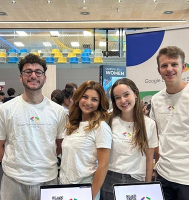 Four young adults smiling at a Google Developer Student Clubs event.
