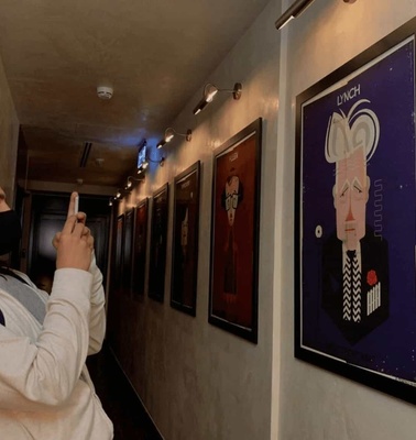A person is taking a photo of colorful portraits in an art gallery.