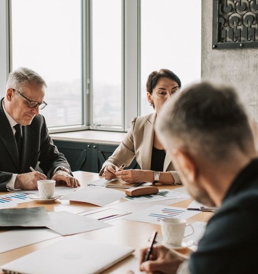 A group of professionals engaged in a business meeting around a conference table.