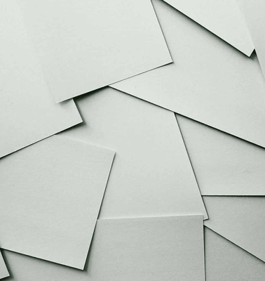 A collection of overlapping white paper sheets with a plain and smooth texture.