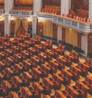 A spacious legislative chamber filled with wooden seats.