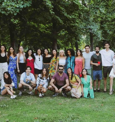 A diverse group of people posing together in a park