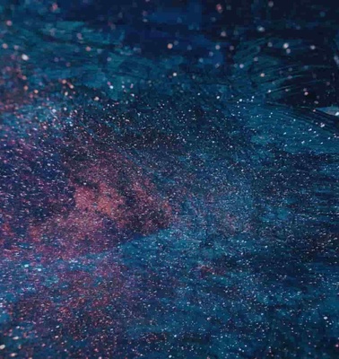 An abstract image depicting a colorful, speckled texture that resembles a cosmic scene