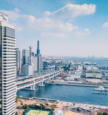 A panoramic view of a modern city skyline with a waterfront and bridges.