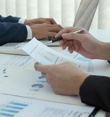 A business meeting with charts and documents on a table.
