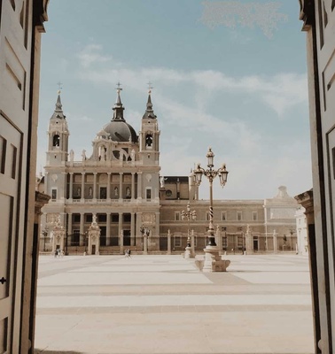 View of a grand historical building with twin spires, seen through an open doorway.