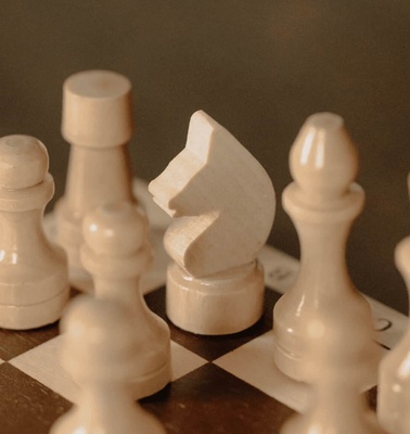 A close-up view of a chessboard with pieces focusing on a white knight, highlighting strategic gameplay.