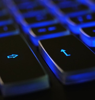 A close-up view of a keyboard with illuminated blue keys.