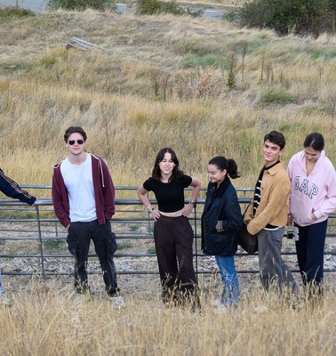 A group of friends posing together in a grassy field.