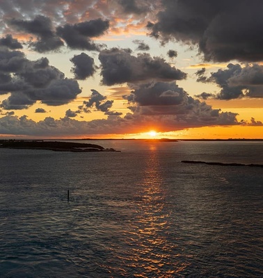 A breathtaking sunset over a calm sea, with clouds reflecting vibrant colors.