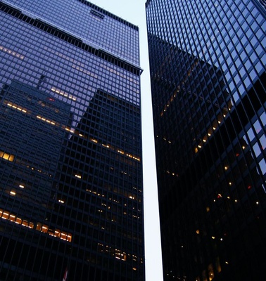 The image features tall modern skyscrapers reflecting the evening light.