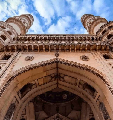 A low-angle view of the intricate facade of a majestic historical building with twin towers under a blue sky.