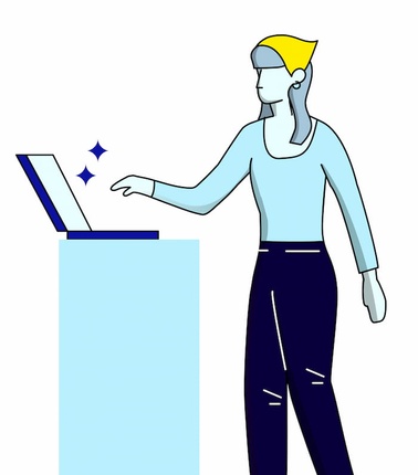 A person working on a laptop at a standing desk.